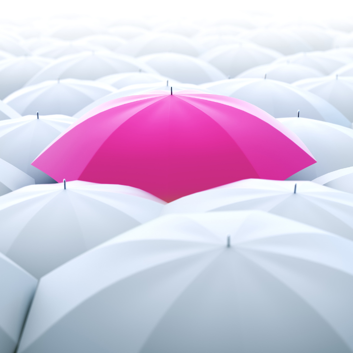 Pink umbrella in a sea of white ones