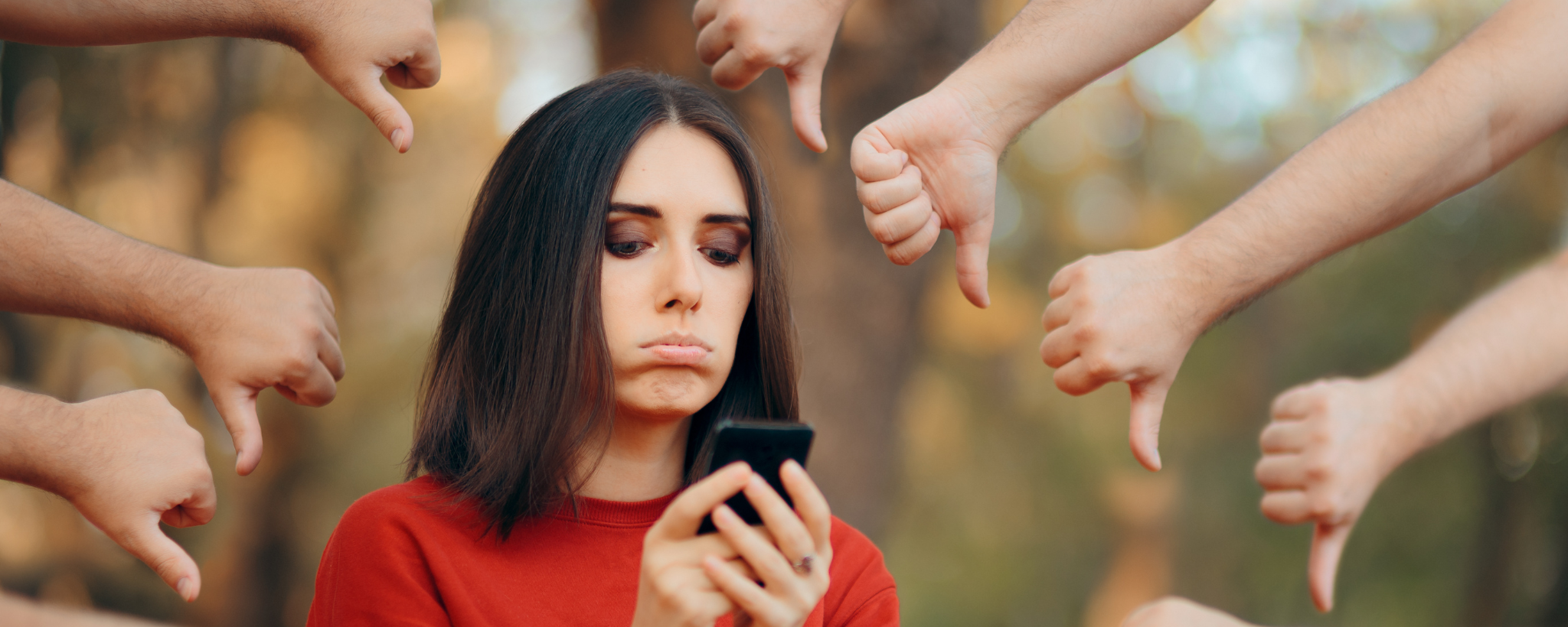 Lady looking sad with phone and lots of hands with thumbs down