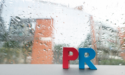PR in front of a window with rain
