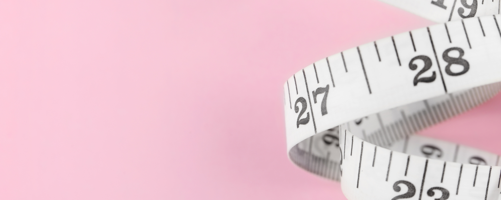 White measuring tape on pink background