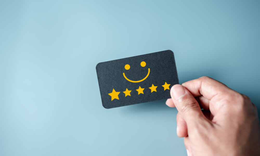 Hand holding card with smiley face and 5 stars