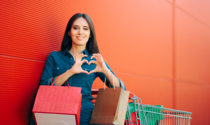 Lady making heart sign with shopping bags