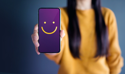 Lady holding phone with smiley face